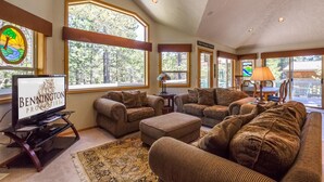 A spacious living room with large windows, a fireplace, and a television on a stand. - Sparks 7 (Bend)