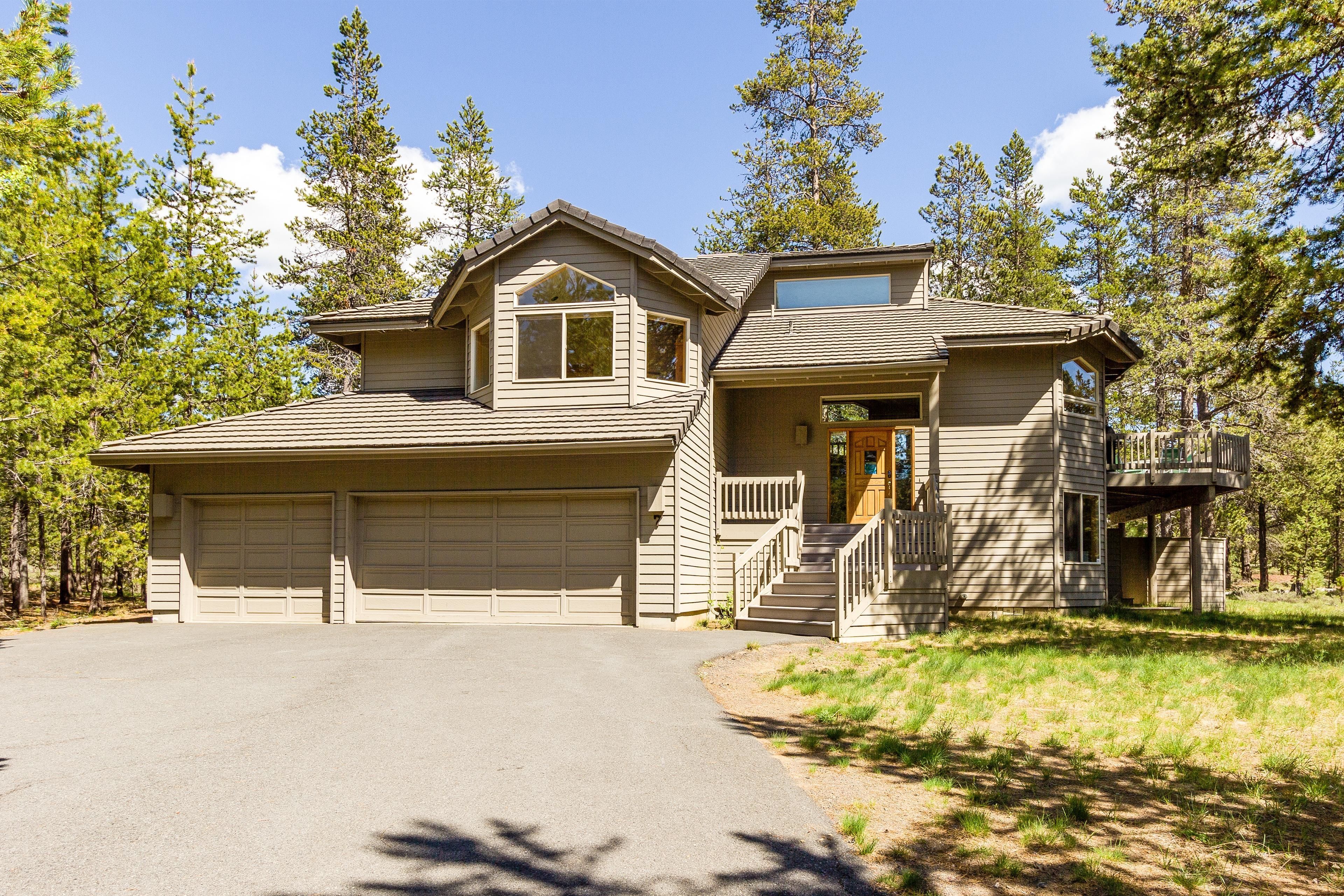 A two-story house with a garage, a covered porch, and a deck.