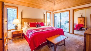 A bedroom with a large bed, two bedside tables with lamps, a bench, and a mirror. - Hoodoo 3 (Bend)