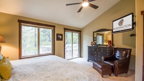 A bedroom with a large bed, a dresser, a chair, and a ceiling fan. - Hoodoo 5 (Bend)