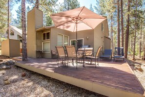 A cabin with a deck, outdoor seating, and a grill area. - Leisure 5 (Bend)