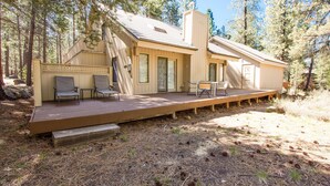 A cabin with a deck, built-in seating, and a fireplace. - Leisure 4 (Bend)