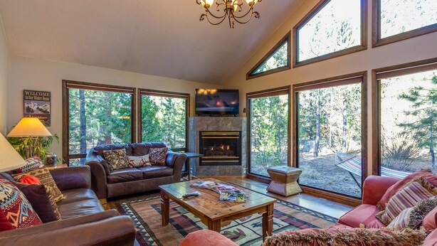 A spacious living room with a fireplace, large windows, and a cozy seating area. - Sparks 5 (Bend)