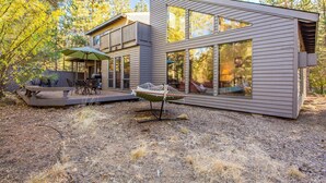 A modern house with large windows, a patio with outdoor furniture, and a hammock. - Sparks 5 (Bend)