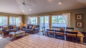 A spacious living room with a fireplace, a dining area, and large windows. - Mt Rose 2 (Bend)