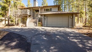 A two-story house with a garage, a covered porch, and a staircase leading to the upper level. - Mt Rose 2 (Bend)