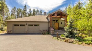 A two-story house with a garage, a covered porch, and a well-maintained garden. - Mt Rose 9 (Bend)