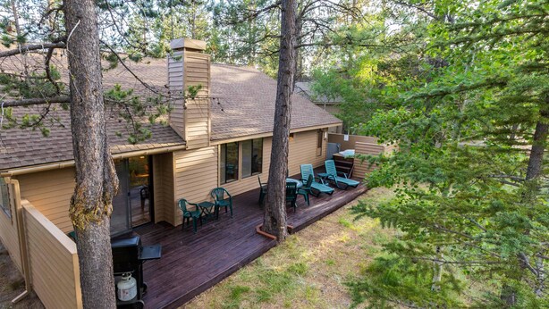 A cabin with a deck, outdoor seating, and a chimney. - Nine Iron 10 (Bend)