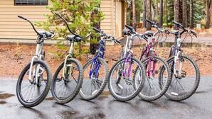 A row of bicycles parked outside a building with a wooden exterior.