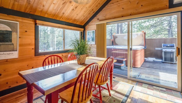 Un intérieur en bois avec une table à manger, des chaises et une grande fenêtre.