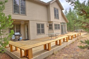 A two-story house with a deck and outdoor seating. - Poplar 43 (Bend)