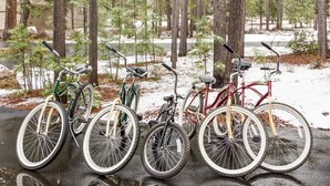 Des vélos garés dans une forêt enneigée.