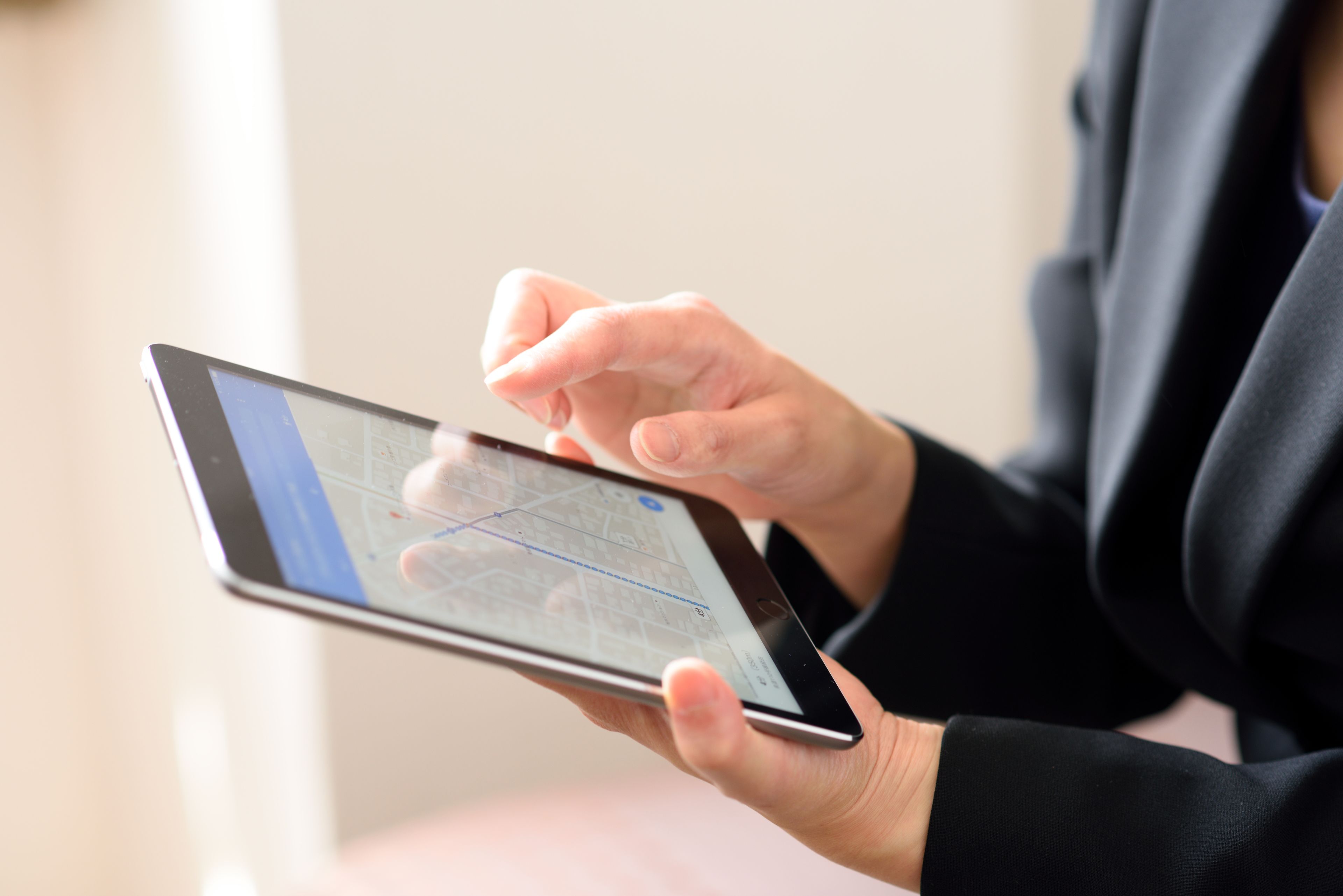 Una persona che tiene in mano un tablet con una mappa visualizzata.