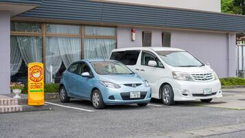 Two parked cars in front of a building with large windows and a fire extinguisher mounted on the wall.