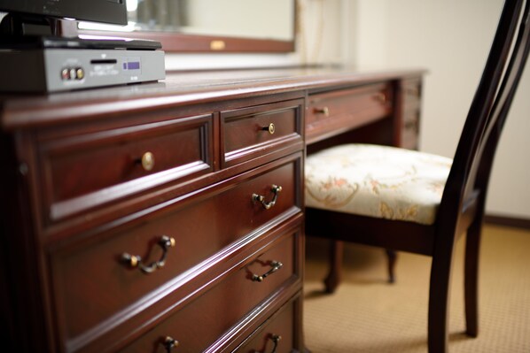 A wooden dresser with drawers and a flat-screen TV on top.