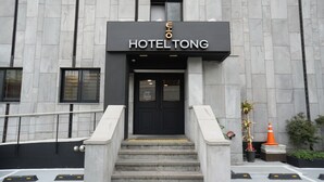 A hotel entrance with a black door and a sign above it. - Hotel Tong Yeondong Jeju (Jeju City)