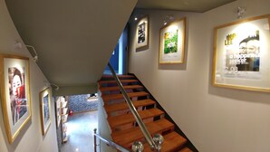 A staircase with wooden steps and metal railings, leading to a lower level. - Hotel Tong Yeondong Jeju (Jeju City)