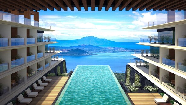 A modern hotel with a pool, multiple balconies, and a view of a mountain and sea. - Escala Tagaytay (Tagaytay)