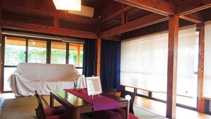 Ein traditioneller japanischer Raum mit Tatami-Bodenbelag, einem niedrigen Tisch, Kissen und einem Futon.