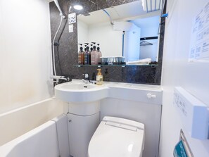 A bathroom with a white sink, a toilet, and a mirror above the sink. - The BREAKFAST HOTEL Fukuoka Tenjin (Fukuoka)