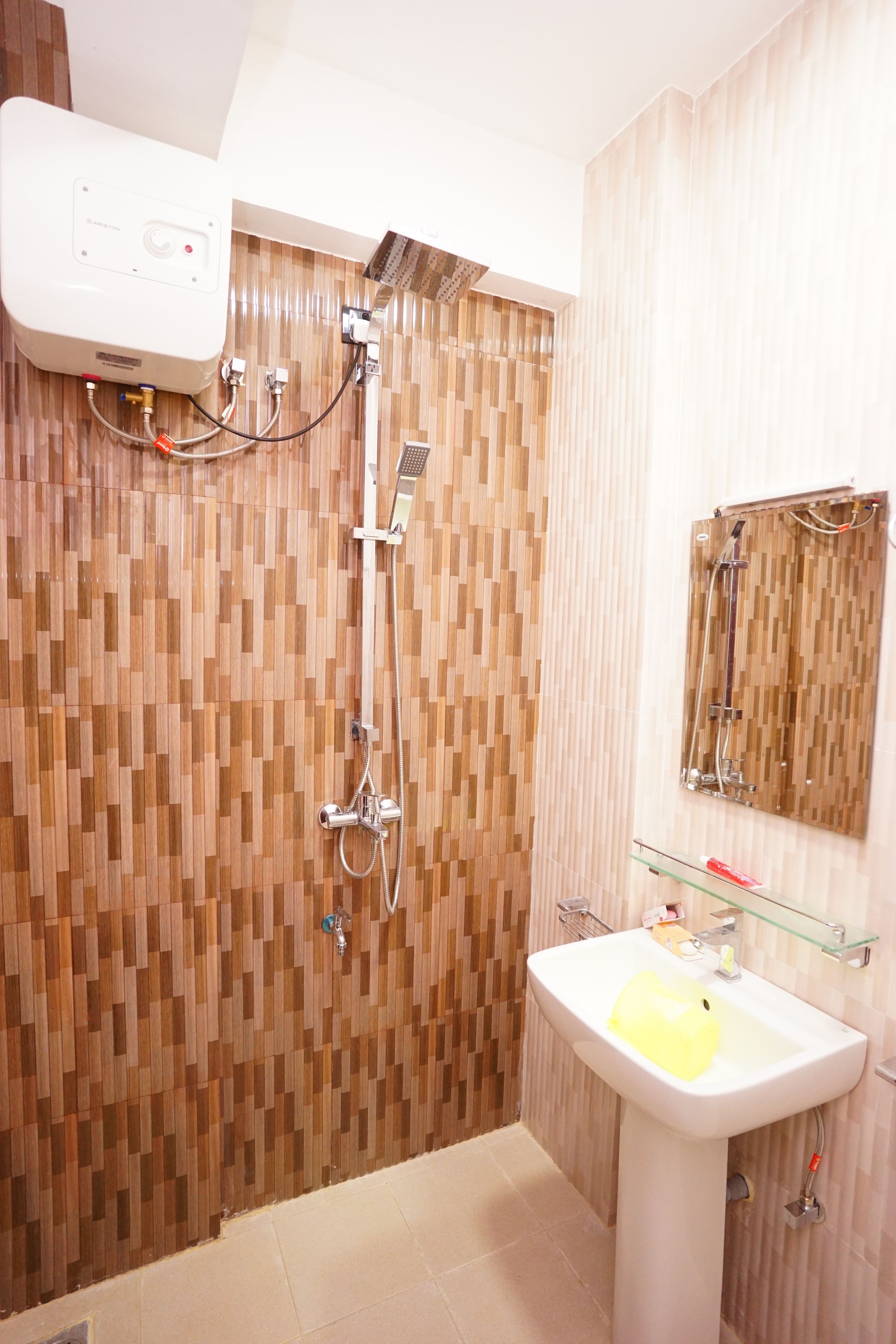 A bathroom with a wooden wall design, a white sink, and a mirror above it.