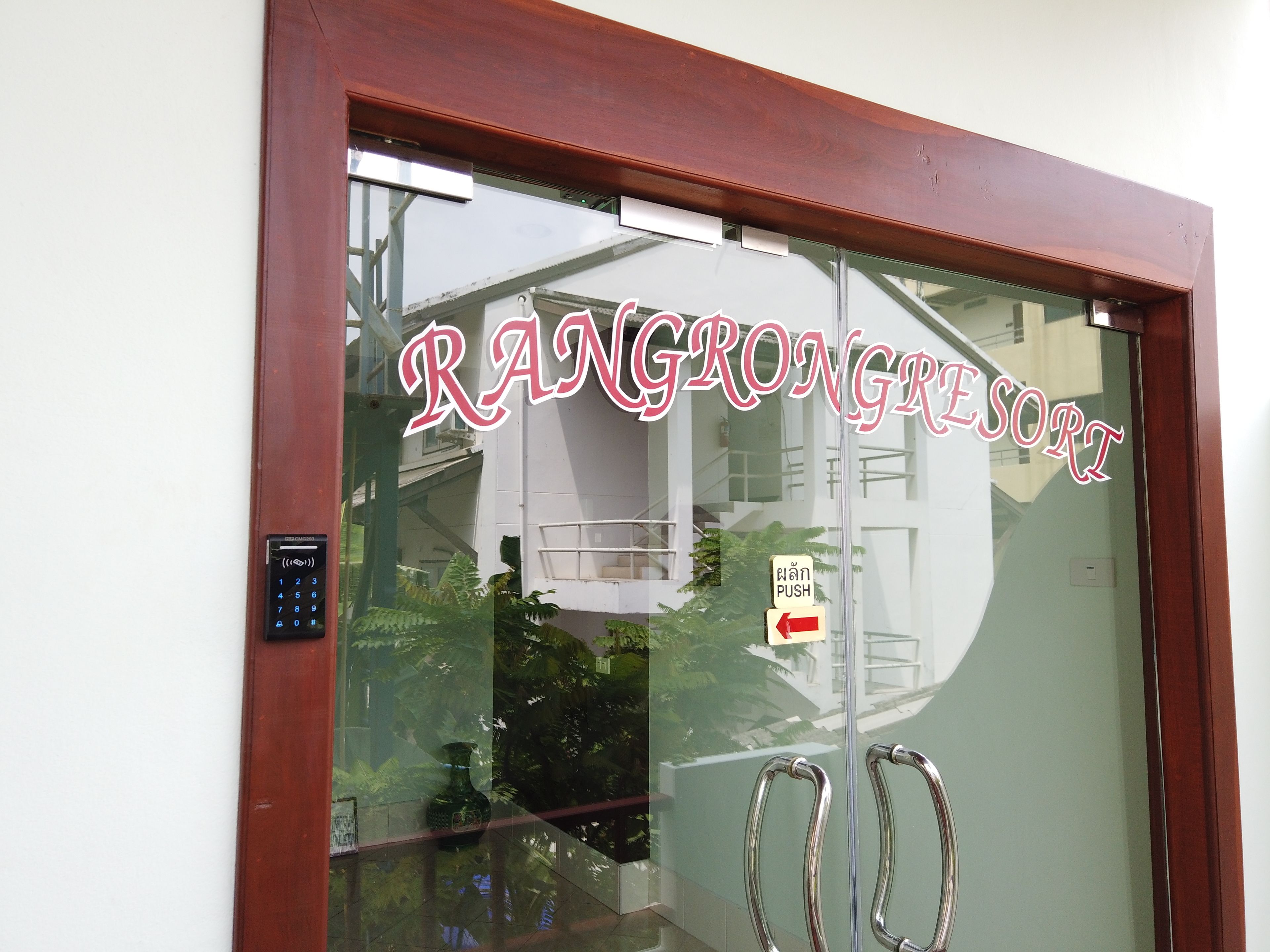 Una puerta de cristal con el nombre "RANGROONGRESORT" en letras rojas.