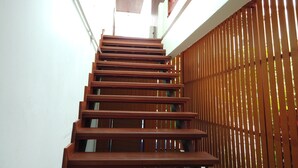A wooden staircase with a white wall on one side and a wooden fence on the other. - RangRong Hotel (Patong)