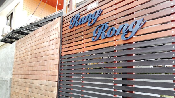 A wooden wall with horizontal slats and a sign that reads "Rang Rong." - RangRong Hotel (Patong)