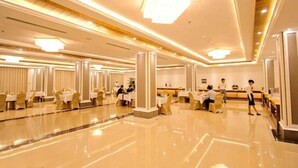 A spacious hotel lobby with multiple dining areas, a reception desk, and a polished floor. - Golden Hotel (Mandalay)