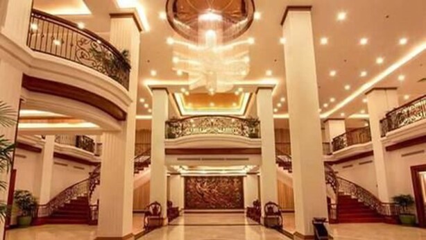 A spacious lobby with a grand staircase, high ceilings, and ornate railings. - Golden Hotel (Mandalay)