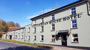 Un edificio de dos plantas con el letrero "Little Dean House Hotel" en la fachada.
