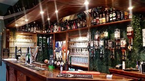 Un bar con una variedad de botellas de licor y una selección de cervezas de barril.