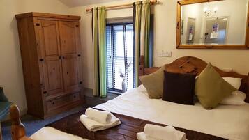 Un dormitorio con una cama grande, un armario de madera y un espejo en la pared.