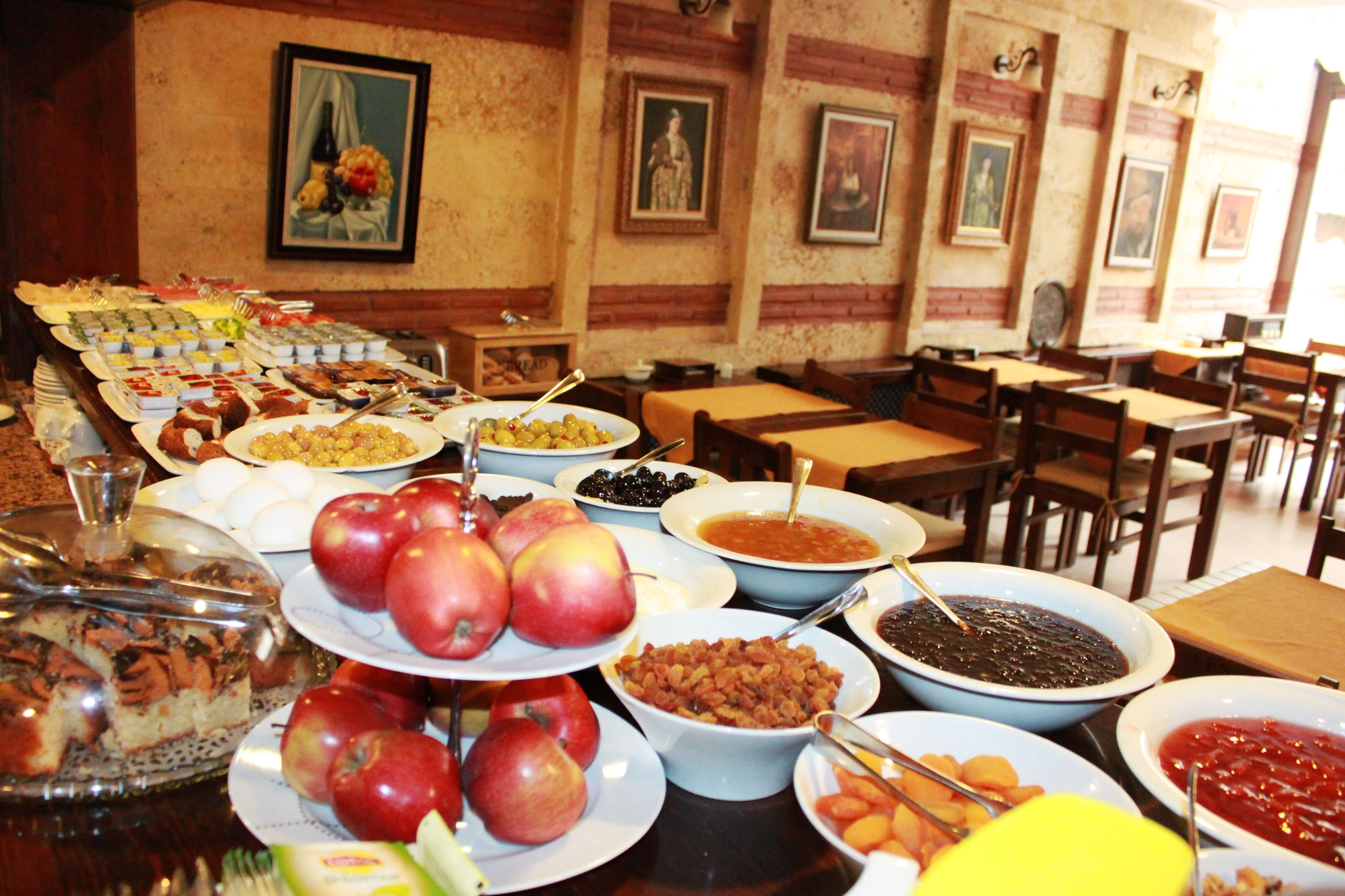 Un buffet con diversi cibi e un'area pranzo con tavoli e sedie.