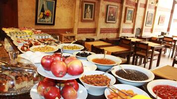 Un buffet con diversi cibi e un'area pranzo con tavoli e sedie.