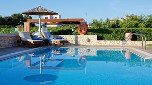 Une piscine avec des chaises longues et un cercle de sauvetage.