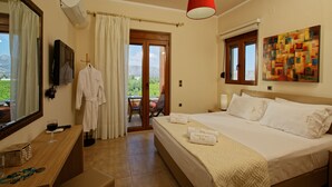 Une chambre d’hôtel avec un lit, un bureau équipé d’un ordinateur, une fenêtre donnant sur un paysage agréable et un luminaire rouge suspendu au plafond.