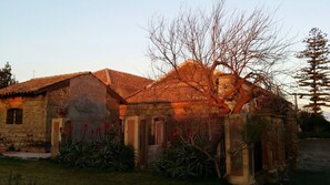 A rustic house with a tiled roof, a wooden door, and a metal gate. - Tenuta del Gelso (Catania)