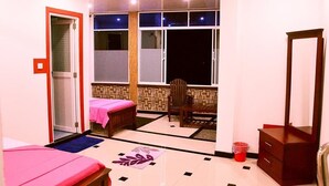 Habitació d'hotel amb un llit, una cadira, un taulell i una finestra amb vistes.