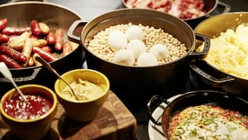 A variety of food items including sausages, boiled eggs, and a dish with a poached egg on top.