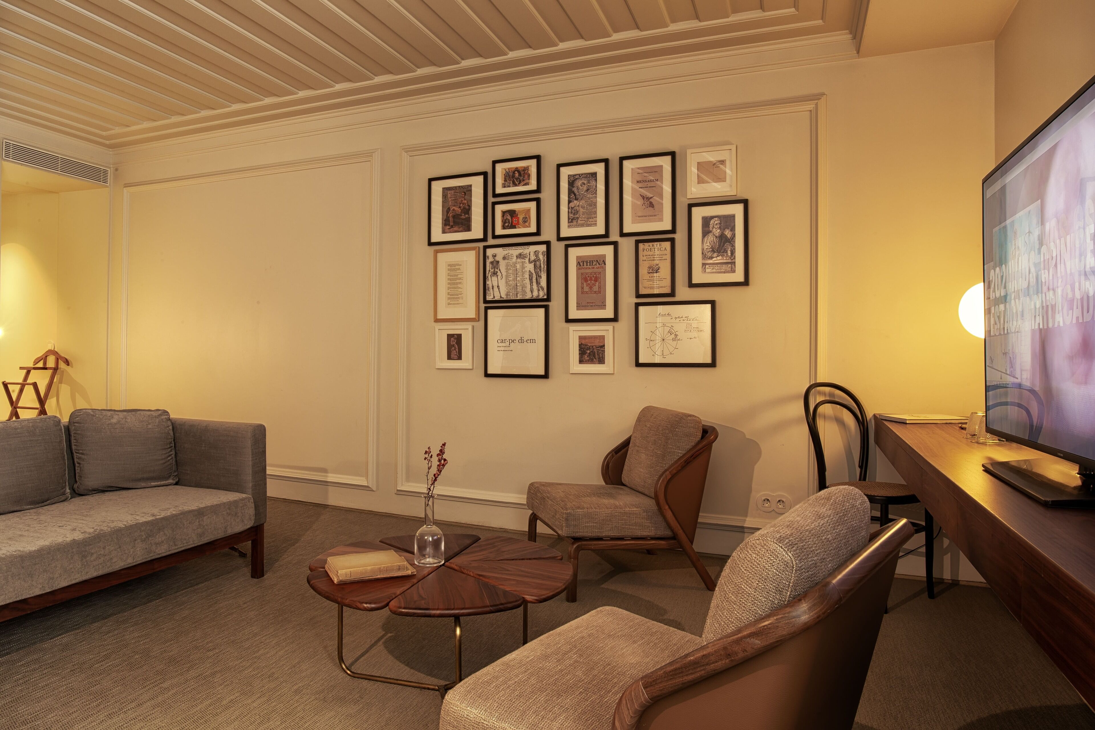 Una sala de estar con sofá, sillones, una mesita de centro y televisión.