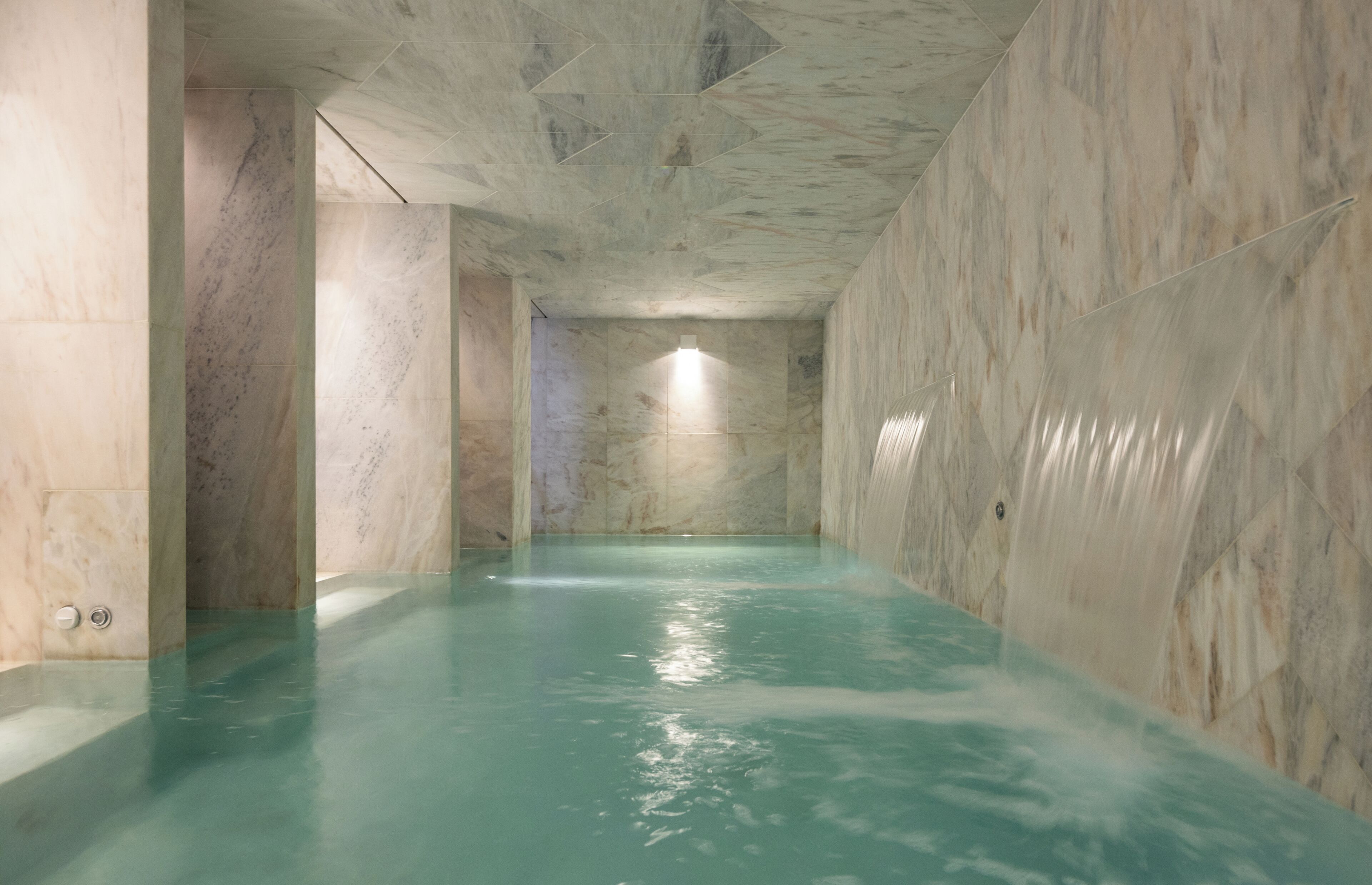 Una piscina techada, sillones reclinables de piscina