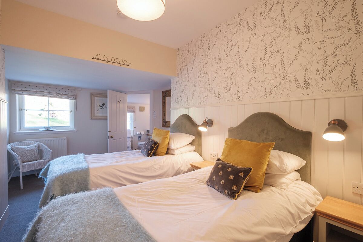 Une chambre avec deux lits, une chaise et une fenêtre.