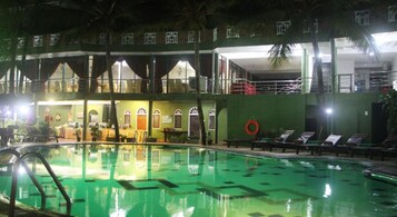 Una piscina al aire libre, sombrillas, sillones reclinables de piscina