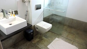 Un baño con lavamanos, inodoro y ducha blancos.