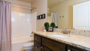 A bathroom with a bathtub, a sink, and a large mirror. - Zions Den (Washington)