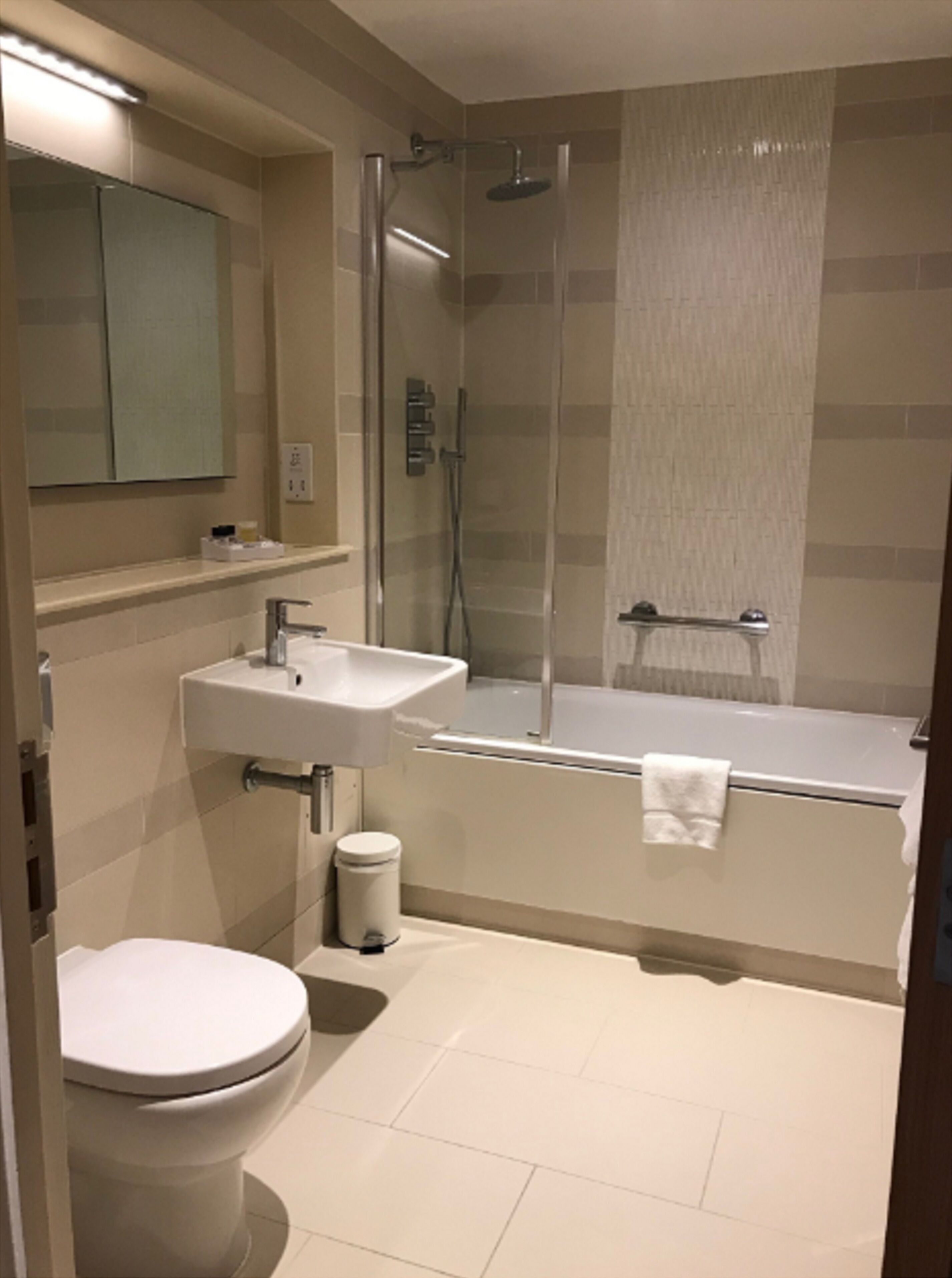 Ein modernes Badezimmer mit Toilette, Waschbecken und einer Duschkabine.