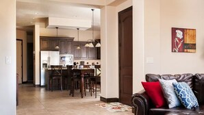 A modern kitchen with dark cabinets, a central island, and pendant lighting. - Coral Vista Villa (Washington)