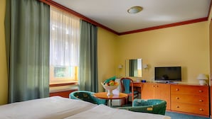 A hotel room with two beds, a television, a desk with a lamp, and a chair. - Ensana Vila Trajan (Piestany)