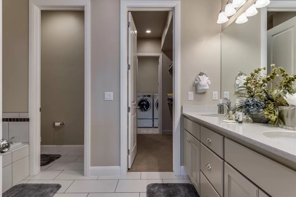 Un baño moderno con un espejo grande, un lavamanos y una zona de ducha.